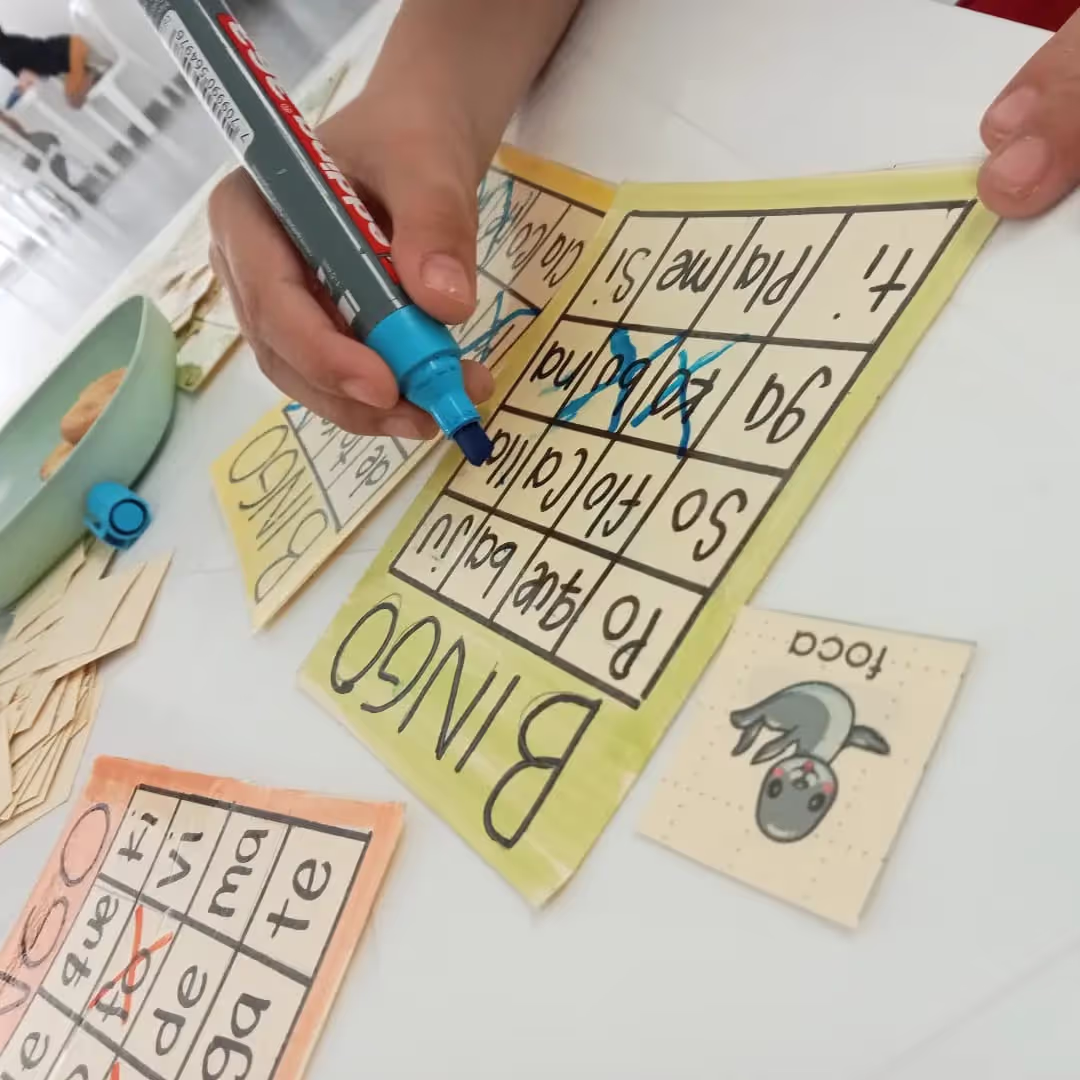 Estudiante jugando bingo como actividad para practicar división de sílabas.